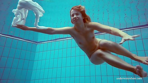 Underwater view of a naked teen blonde prurient Melisa Darkova swimming around reaching the bottom showing off her ass