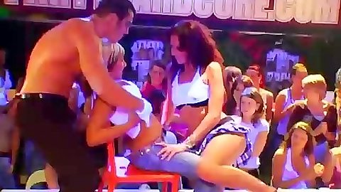 Group amateur dancing and undressing on club stage in public