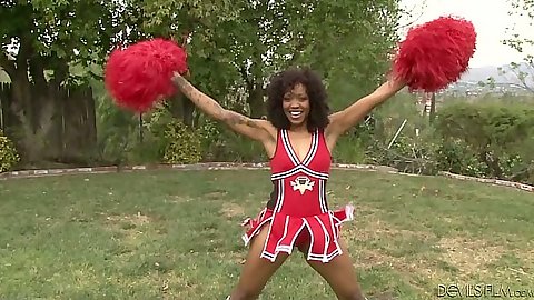 Ebony cheerleader outdoors in uniform with  Lotus Lain practicing her moves